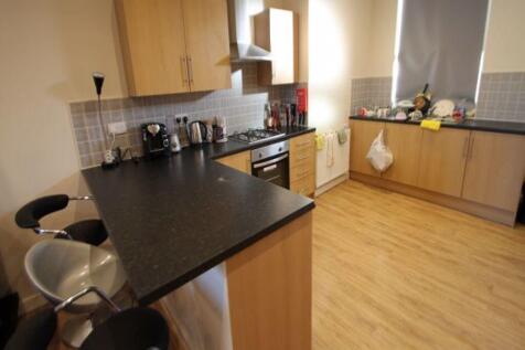A modern kitchen with wooden cabinetry and blac...
