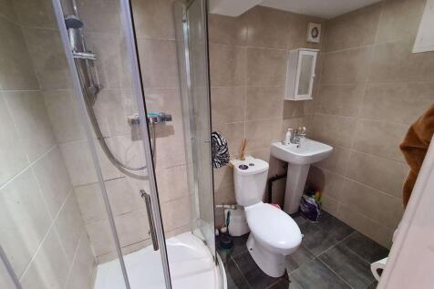 A modern bathroom featuring a glass-enclosed sh...