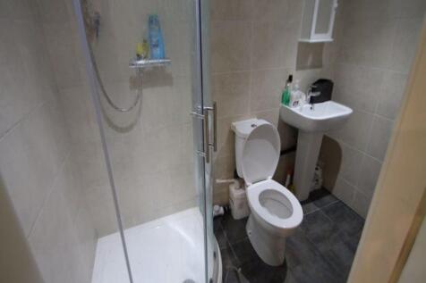 A modern bathroom featuring a curved glass show...