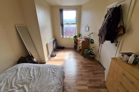 A cozy single bedroom featuring a large window ...