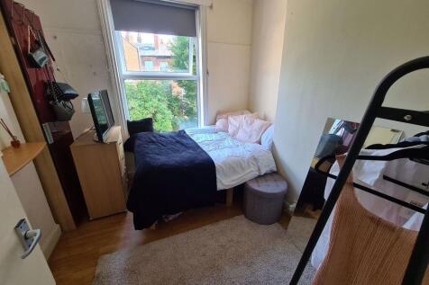 A cozy single bedroom featuring a single bed po...