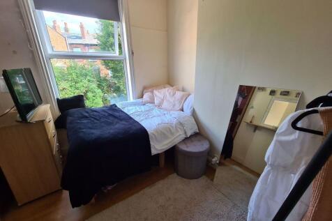 Cozy single bedroom featuring a comfortable bed...