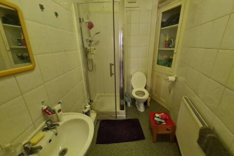 Well-maintained bathroom featuring a shower enc...