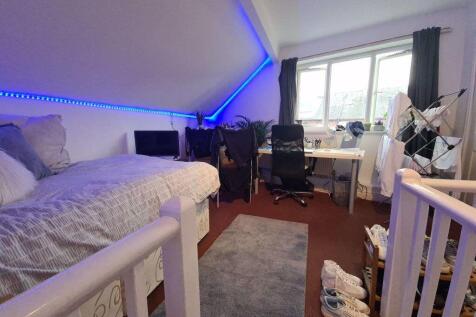 A spacious and well-lit bedroom featuring a com...