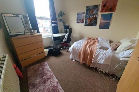 A cozy bedroom featuring a double bed, a window...