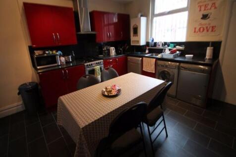 A contemporary kitchen featuring modern red cab...