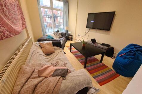 A cozy single bedroom featuring a bed, a wall-m...