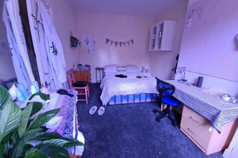 A spacious and well-lit master bedroom featurin...