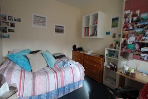 A cozy bedroom featuring a double bed dressed w...