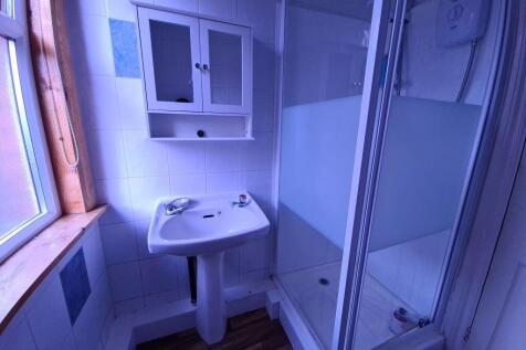 A clean and well-lit bathroom featuring a showe...