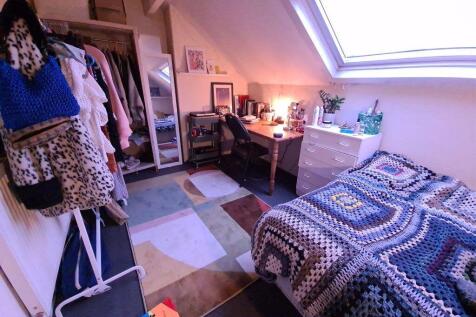 Bright and cozy bedroom featuring a comfortable...