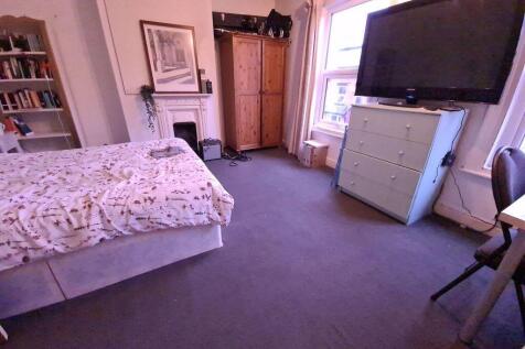 A cozy bedroom featuring a comfortable bed, amp...