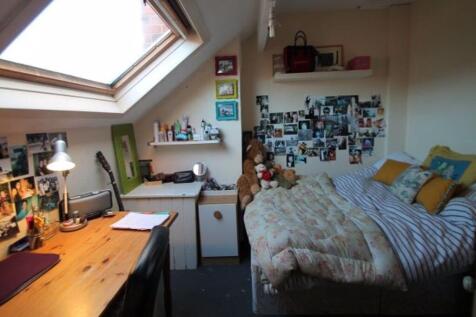 A cozy bedroom with a skylight window providing...