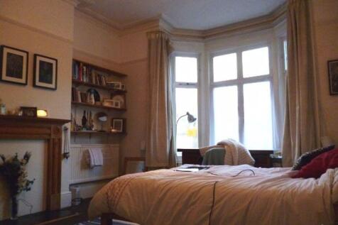 A cozy bedroom featuring a large window allowin...