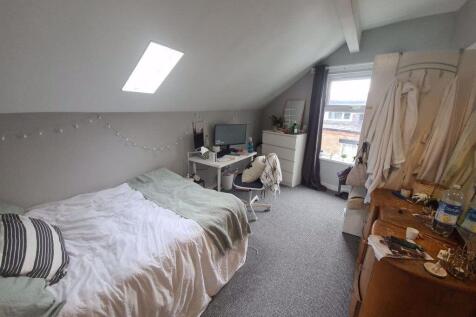 A cozy bedroom featuring a single bed with a st...