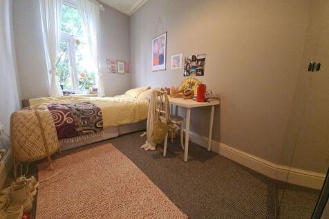 A cozy bedroom featuring a comfortable single b...