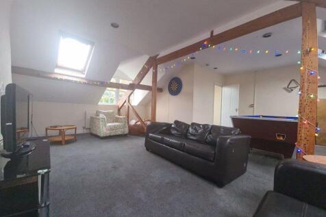 A spacious and welcoming living room with large...