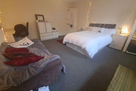 A well-maintained bedroom featuring a large dou...