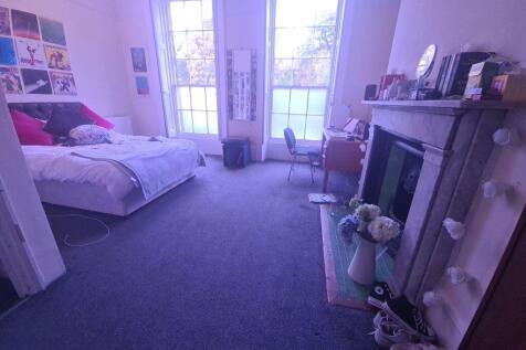 A spacious and well-lit living room featuring c...