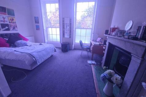 A well-lit bedroom featuring a comfortable bed,...