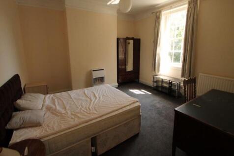 A cozy bedroom with a large window that lets in...