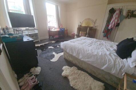 Spacious master bedroom featuring a large bed, ...