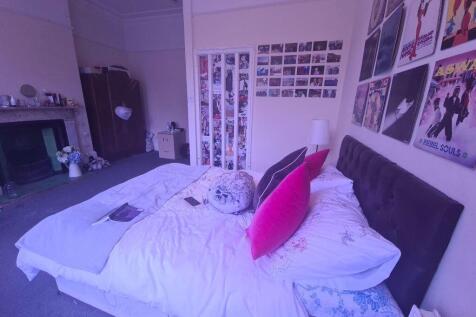 A cozy single bedroom featuring a neatly made b...