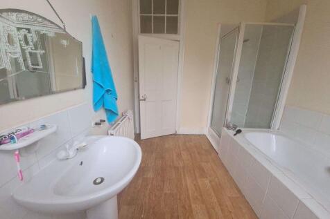 Bright and tidy bathroom featuring a modern sho...