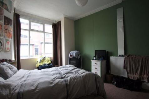 A spacious master bedroom featuring a large bed...