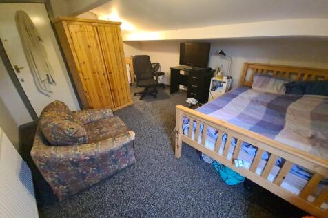 A cozy bedroom featuring a comfortable double b...