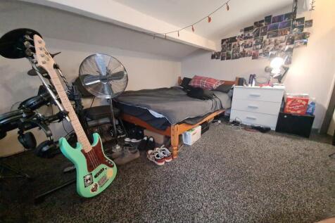 A well-used bedroom featuring a bed, musical in...