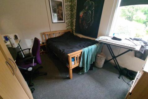 A cozy bedroom featuring a wooden bed frame, a ...