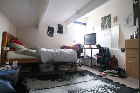 A cozy bedroom with a single bed, a desk, and a...