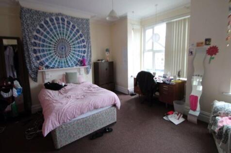 A bright and welcoming bedroom featuring a comf...