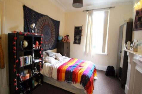 A cozy bedroom featuring a double bed adorned w...