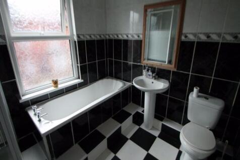 A spacious bathroom featuring a large bathtub, ...