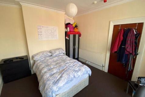 A cozy bedroom with a double bed, a wardrobe, a...