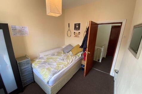 A cozy single bedroom with a comfortable bed, a...