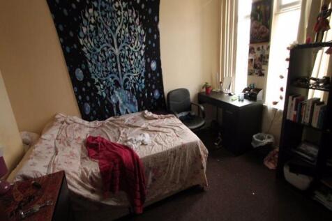 A cozy bedroom featuring a double bed with patt...