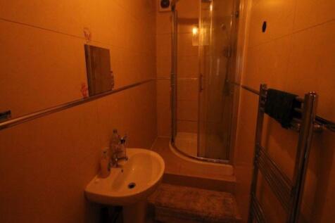 A compact bathroom featuring a shower cubicle a...