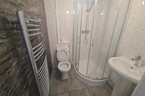 A modern bathroom featuring a curved shower enc...