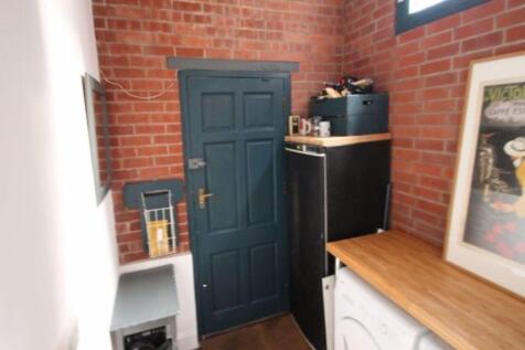 A well-lit kitchen area featuring a wooden coun...