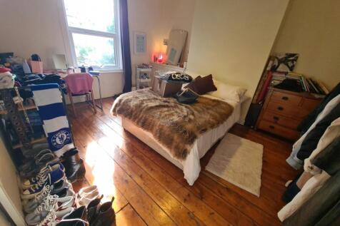 A spacious master bedroom featuring a large bed...