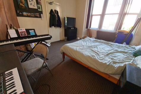 A spacious, well-lit master bedroom featuring a...