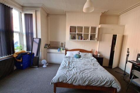 A spacious master bedroom with a double bed and...
