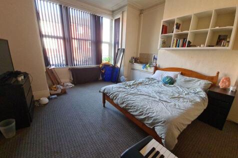 A bright and tidy bedroom featuring a large dou...