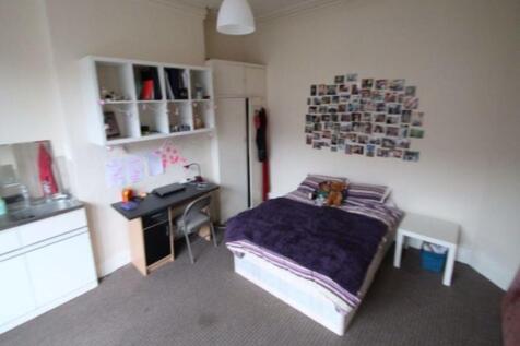 A cozy and tidy single bedroom featuring a comf...