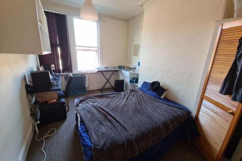 A cozy bedroom featuring a double bed with a be...