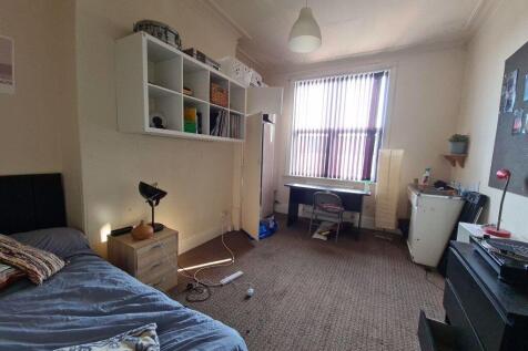 A cozy bedroom with a bed and a window allowing...