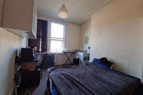 A modest bedroom featuring a single bed and a w...